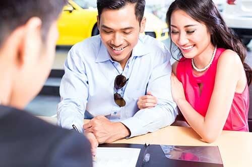 Couple excitedly purchasing new car - Book an appointment at major world