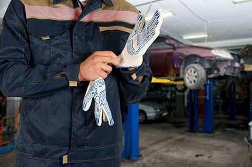 Mechanic putting on gloves in service garage