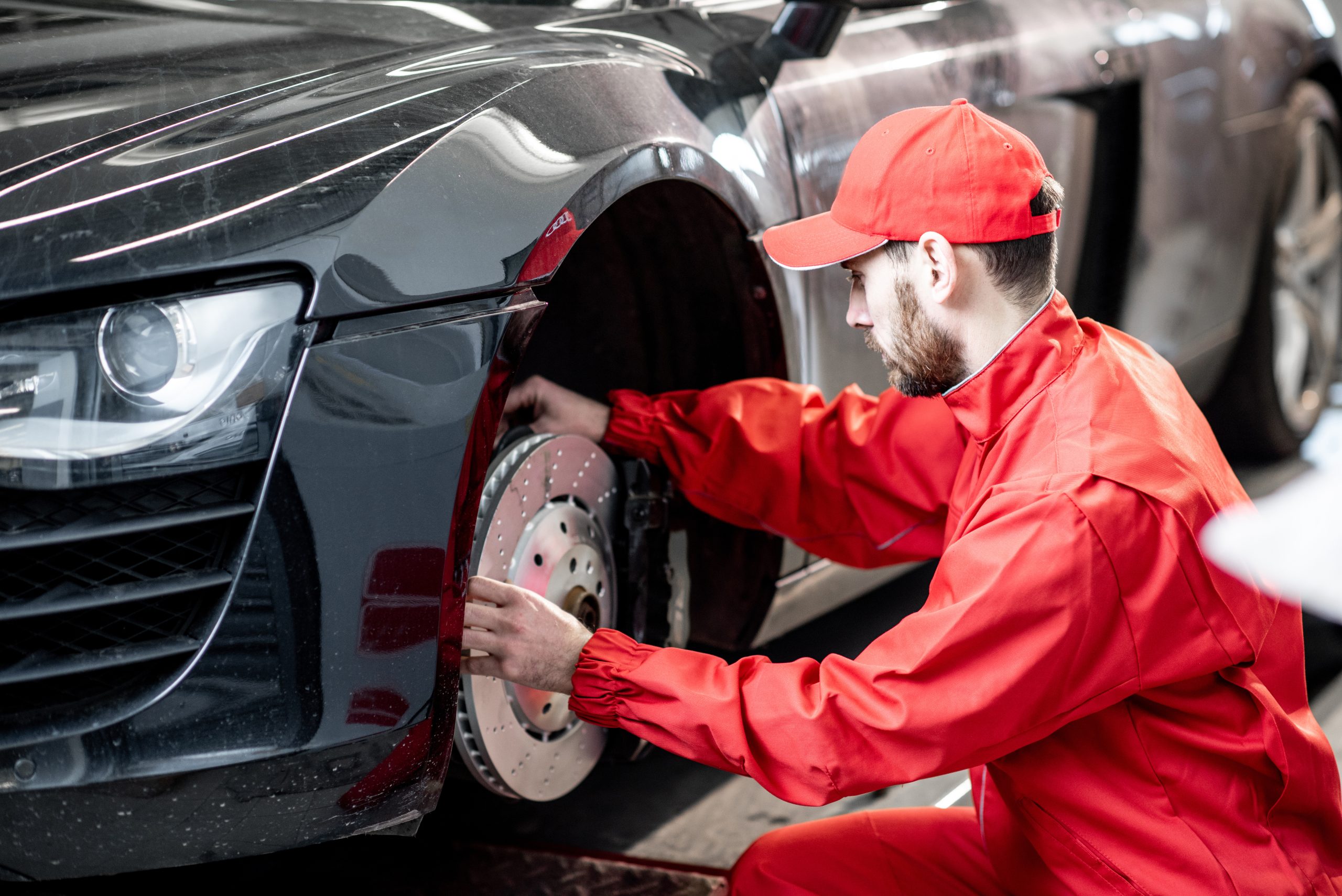 mechanic inspecting brakes - how to know when you need new brakes